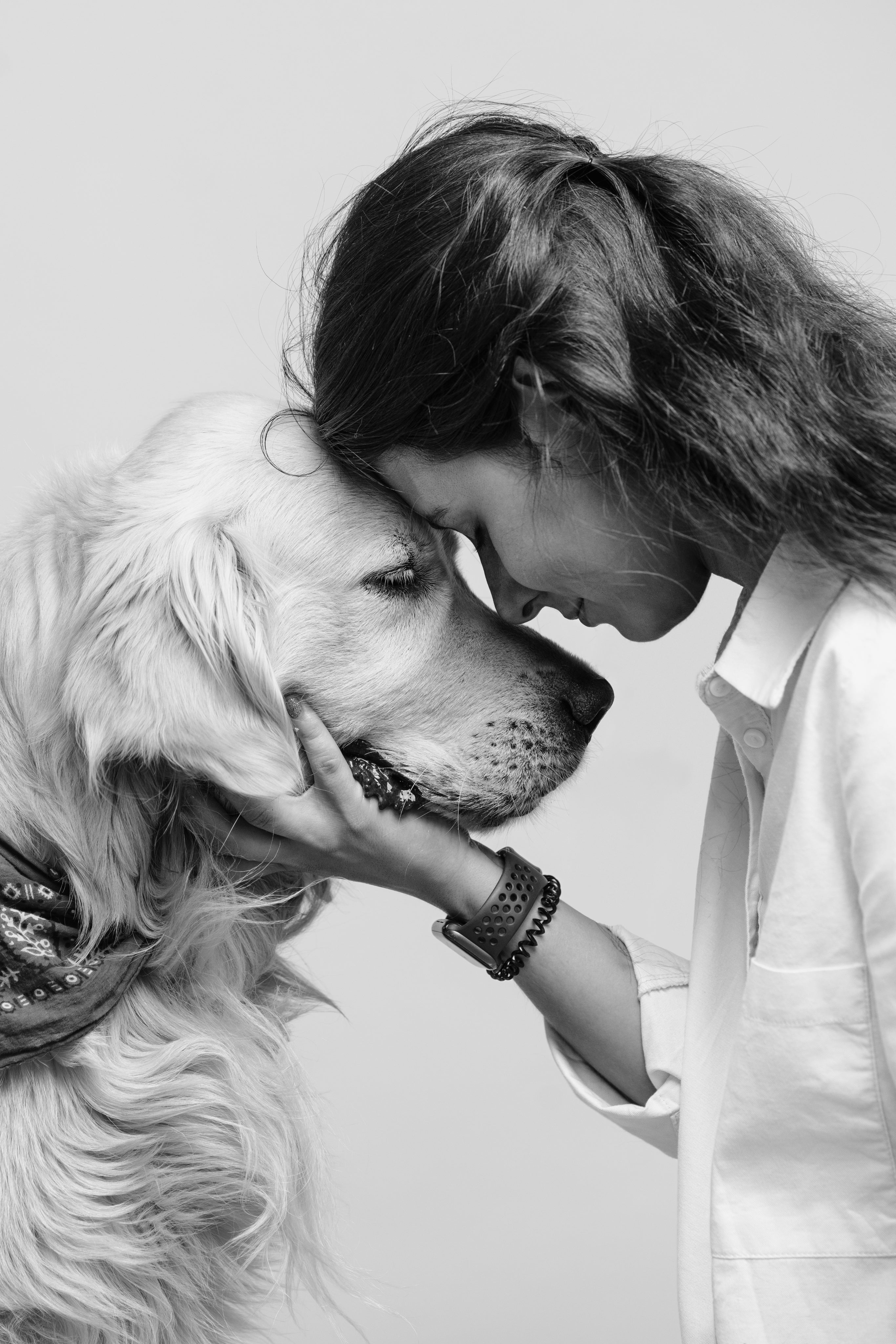 Close-up of a woman gently touching foreheads with a golden retriever, symbolizing trust, respect, and the deep bond at the heart of Little Lupo’s honor code.