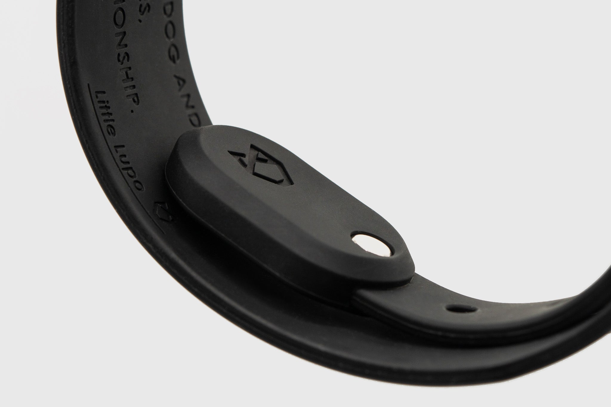 Close-up of Little Lupo waterproof AirTag Holder securely fitted on a collar, showing the debossed Little Lupo logo and premium LFGB silicone material.