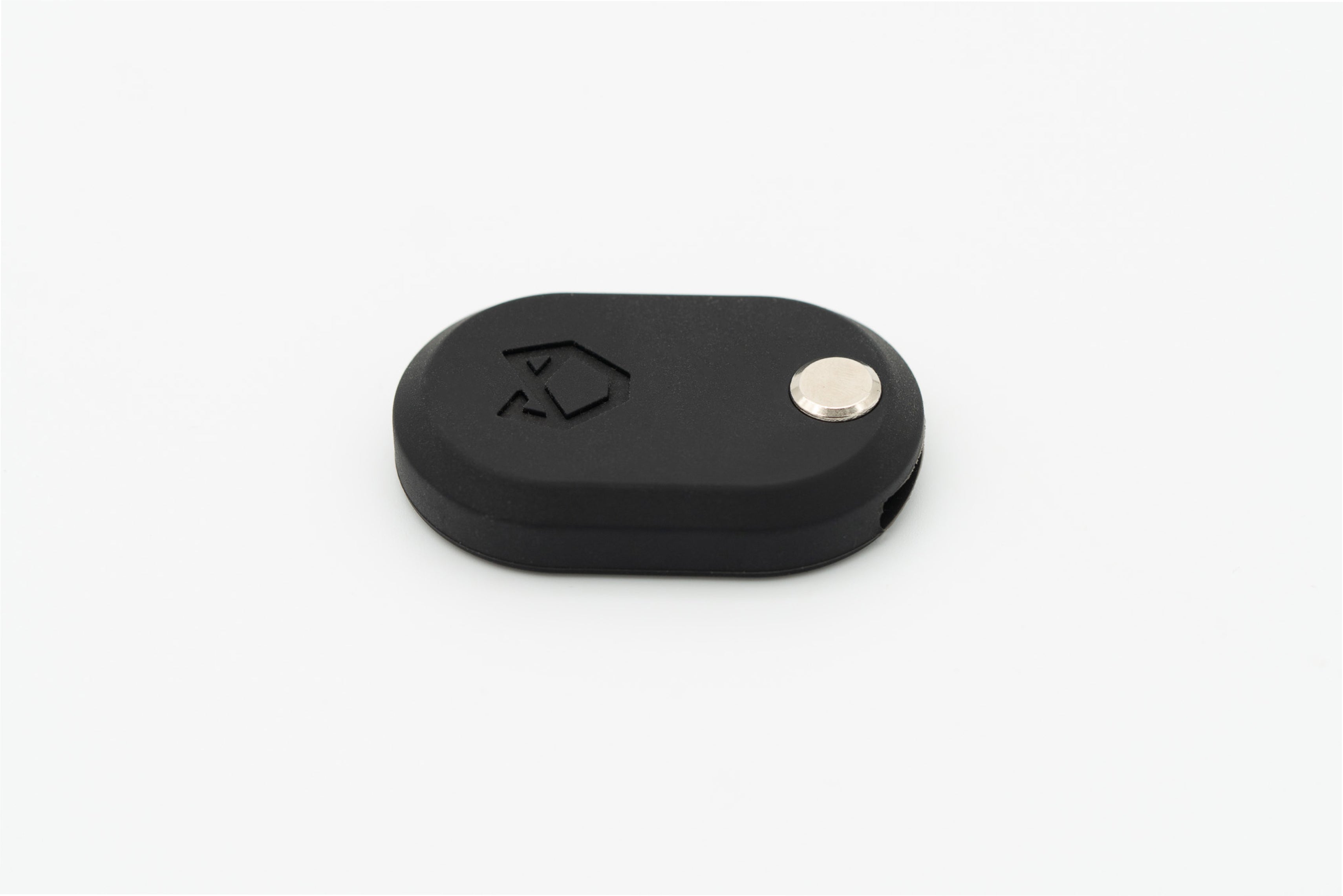 Top view of the Little Lupo AirTag Holder, showcasing its sleek black LFGB silicone design with a debossed logo and durable silver nut, on a white background.