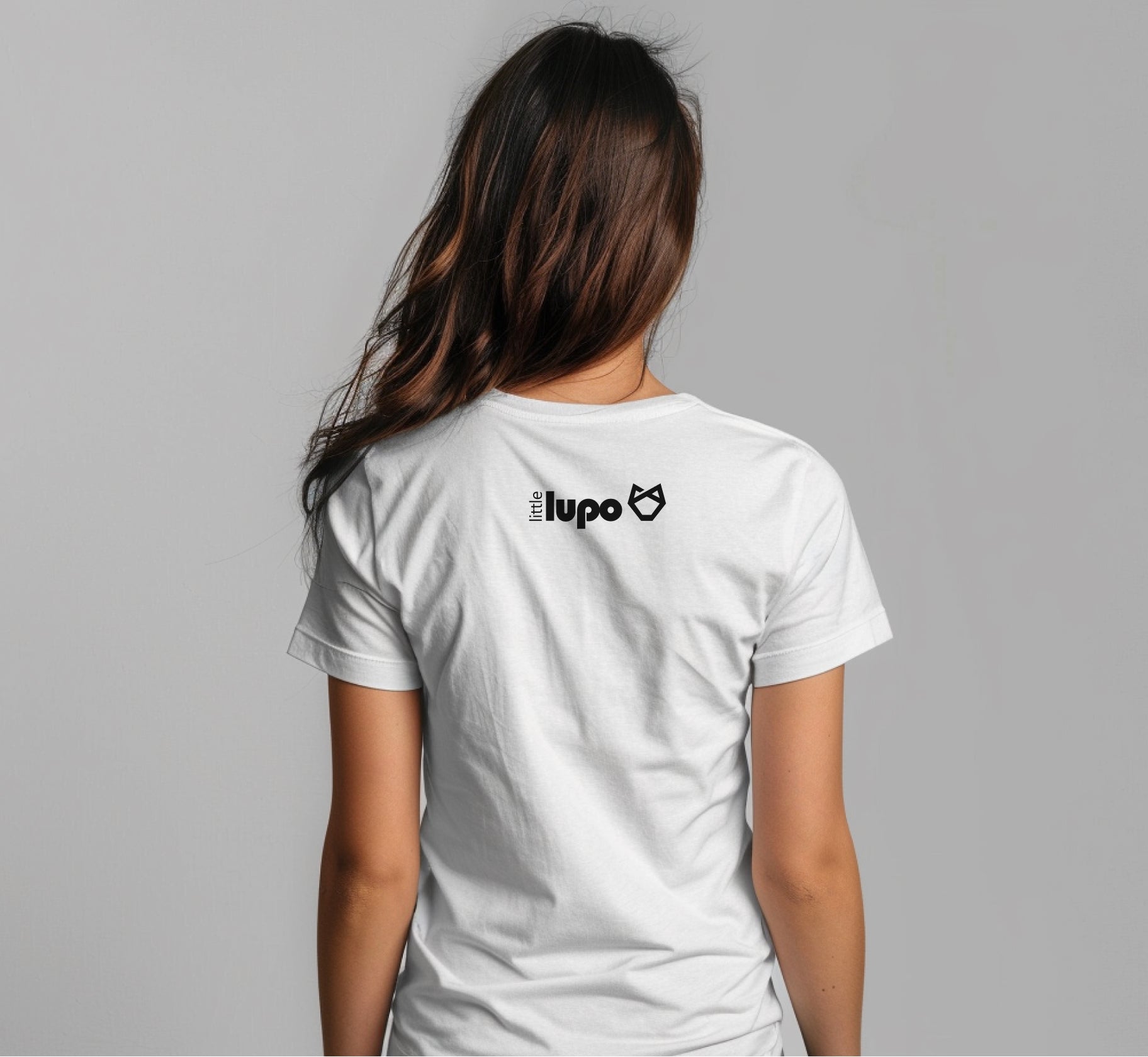 Back view of a white Little Lupo t-shirt on a young woman, showcasing the brand logo and the shirt's breathable, soft cotton material.