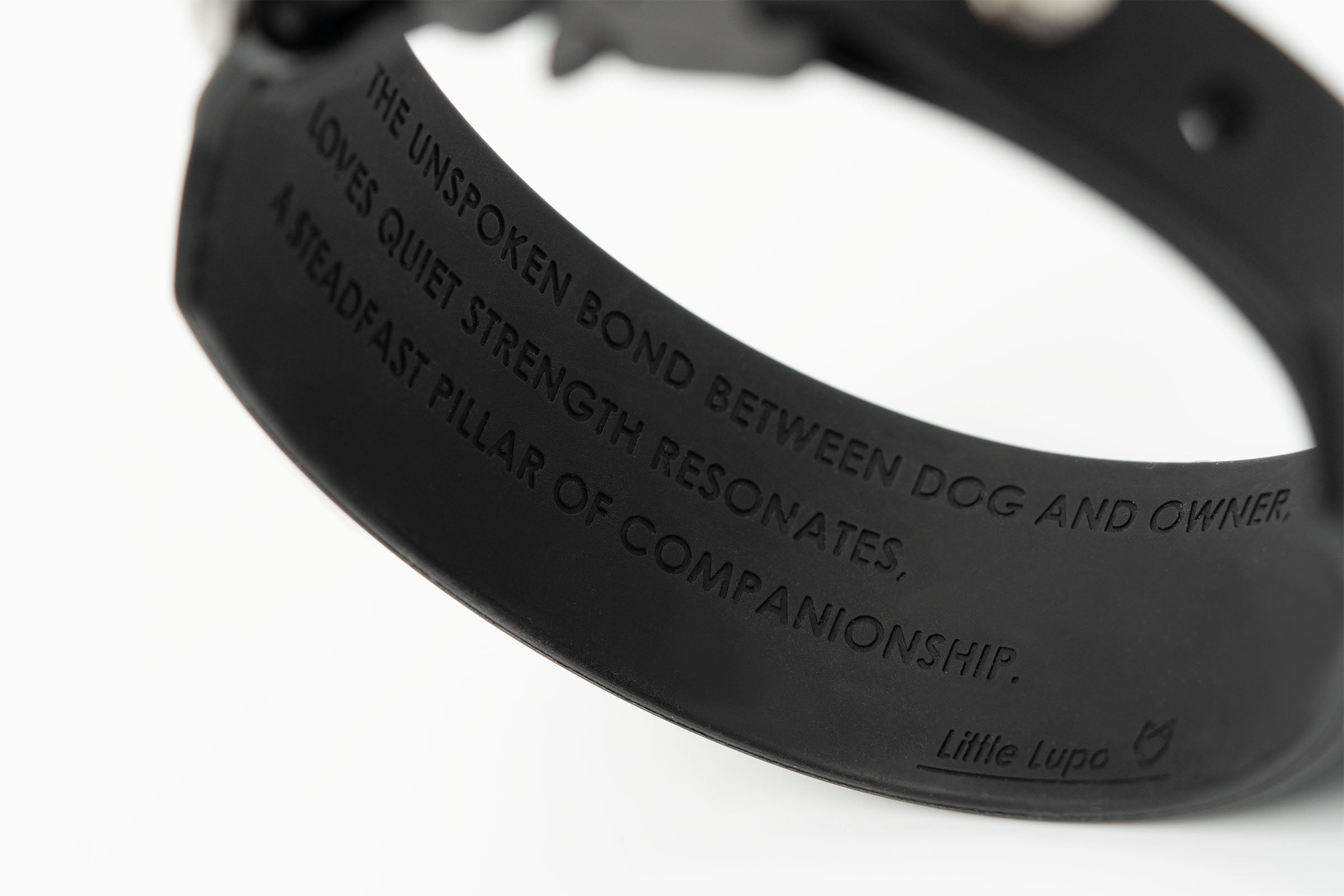Interior view of Little Lupo Collar C2 showing debossed text "IN THE UNSPOKEN BOND BETWEEN DOG AND OWNER, LOVE'S QUIET STRENGTH RESONATES, A STEADFAST PILLAR OF COMPANIONSHIP. Little Lupo" highlighting brand values on the waterproof LFGB silicone.