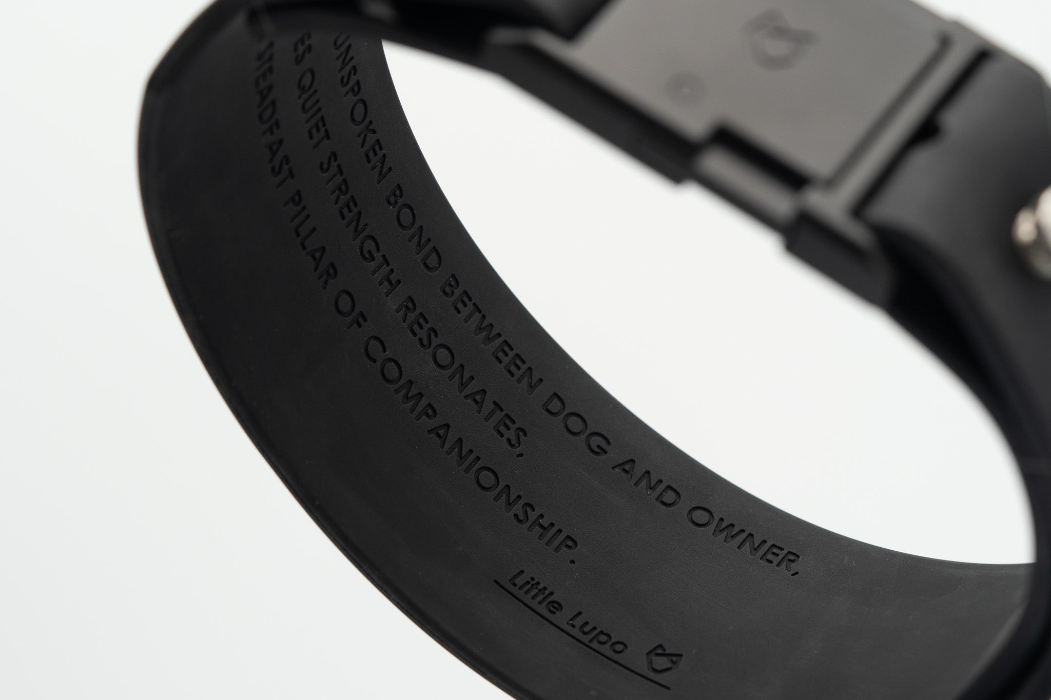 Interior view of Little Lupo Collar C1 showing debossed text "IN THE UNSPOKEN BOND BETWEEN DOG AND OWNER, LOVE'S QUIET STRENGTH RESONATES, A STEADFAST PILLAR OF COMPANIONSHIP. Little Lupo" highlighting brand values on the waterproof LFGB silicone.