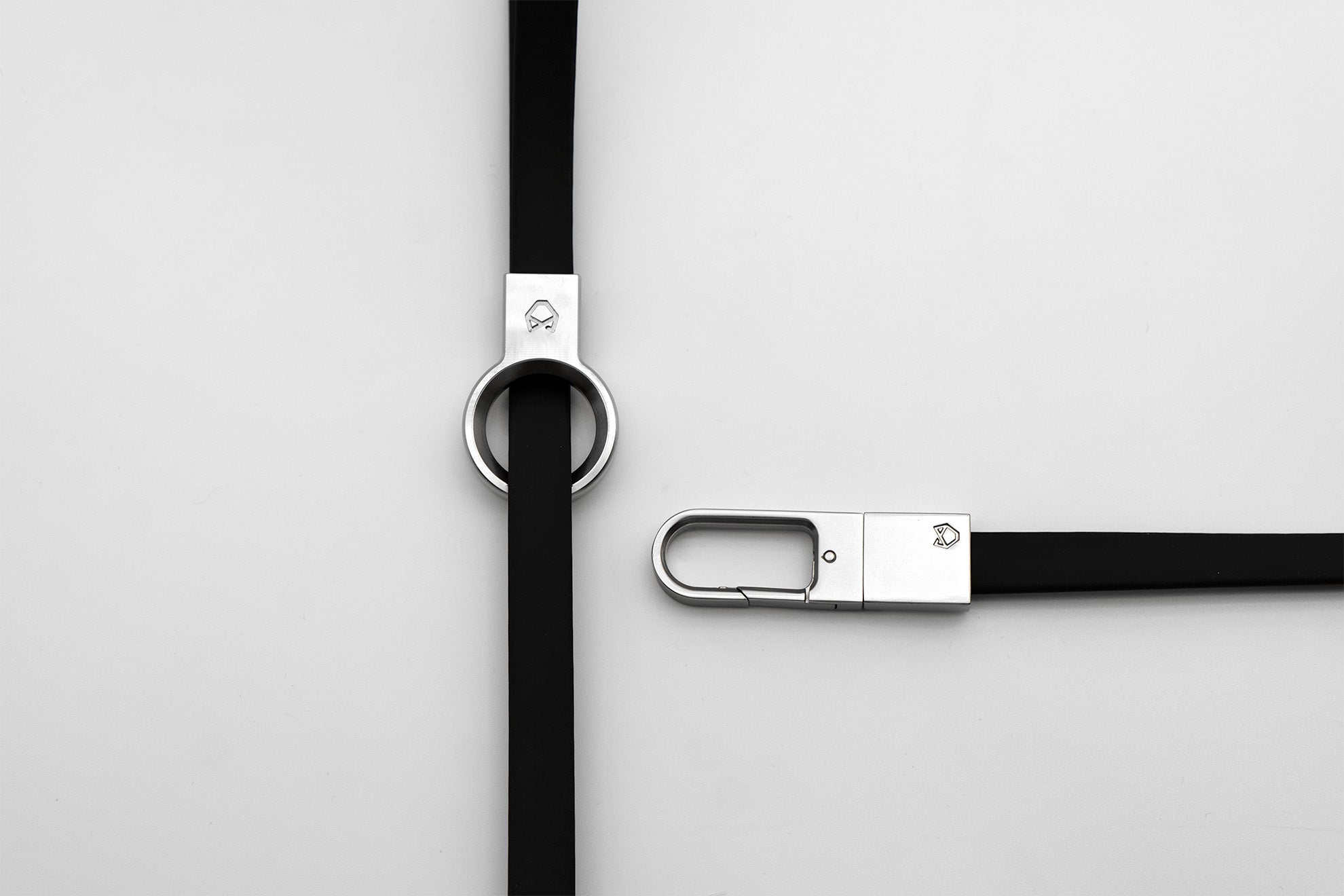 Overhead view of the Little Lupo Leash L3's stainless steel handle ring and durable clip, showcasing the high-quality craftsmanship of the black silicone-coated tactical nylon webbing.