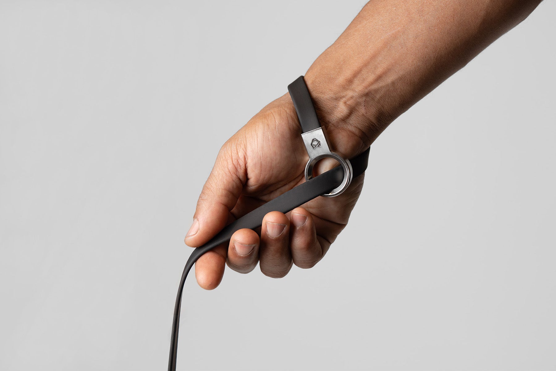 A male hand wearing the Little Lupo Leash L3's slip handle around his wrist, showcasing its elegant, comfortable and secure fit, emphasizing ease of use.