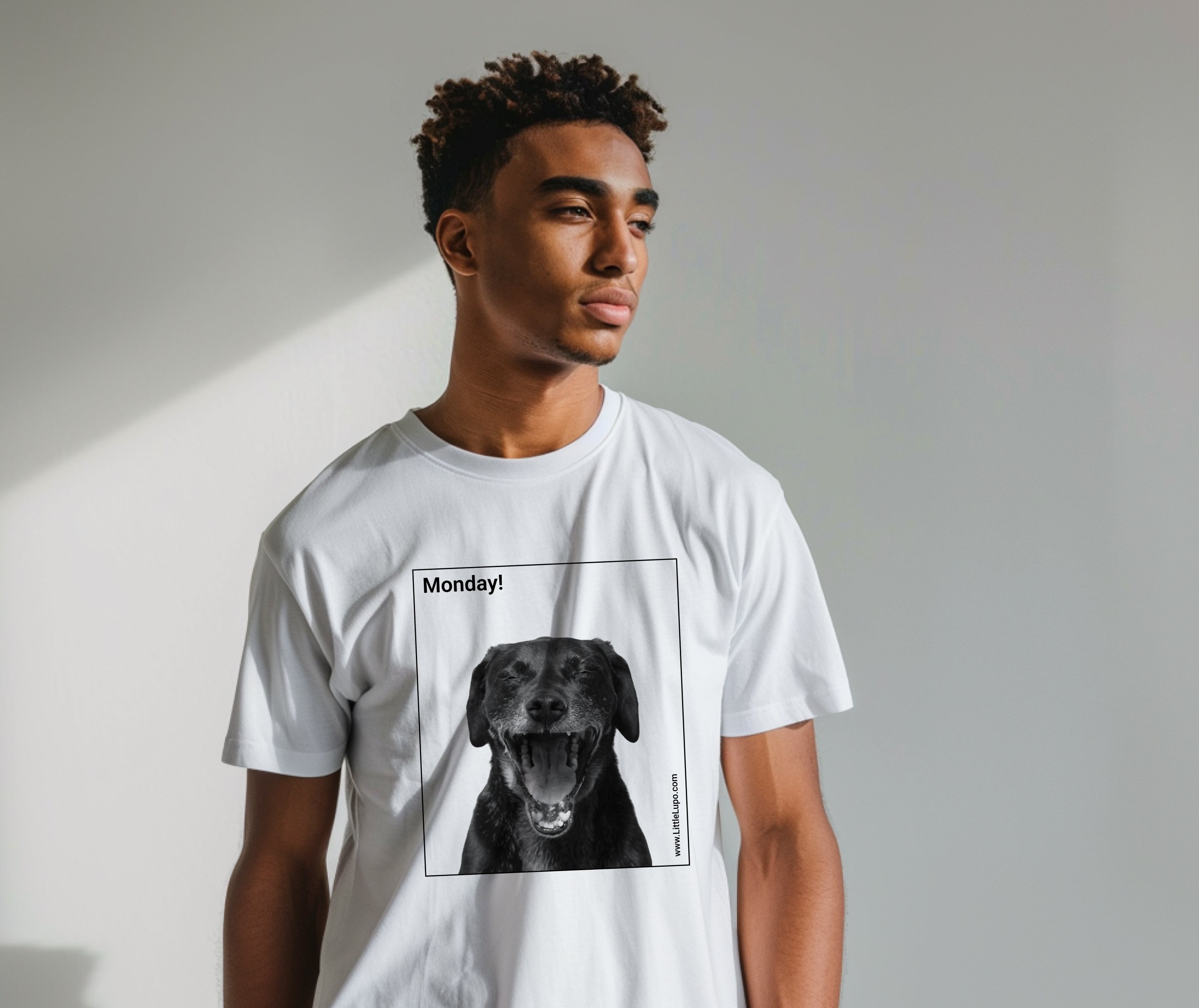 White Little Lupo t-shirt on a young adult man with a humorous "Monday!" graphic featuring a screaming dog's face inside a square, made from soft Airlume combed cotton for pet owners.