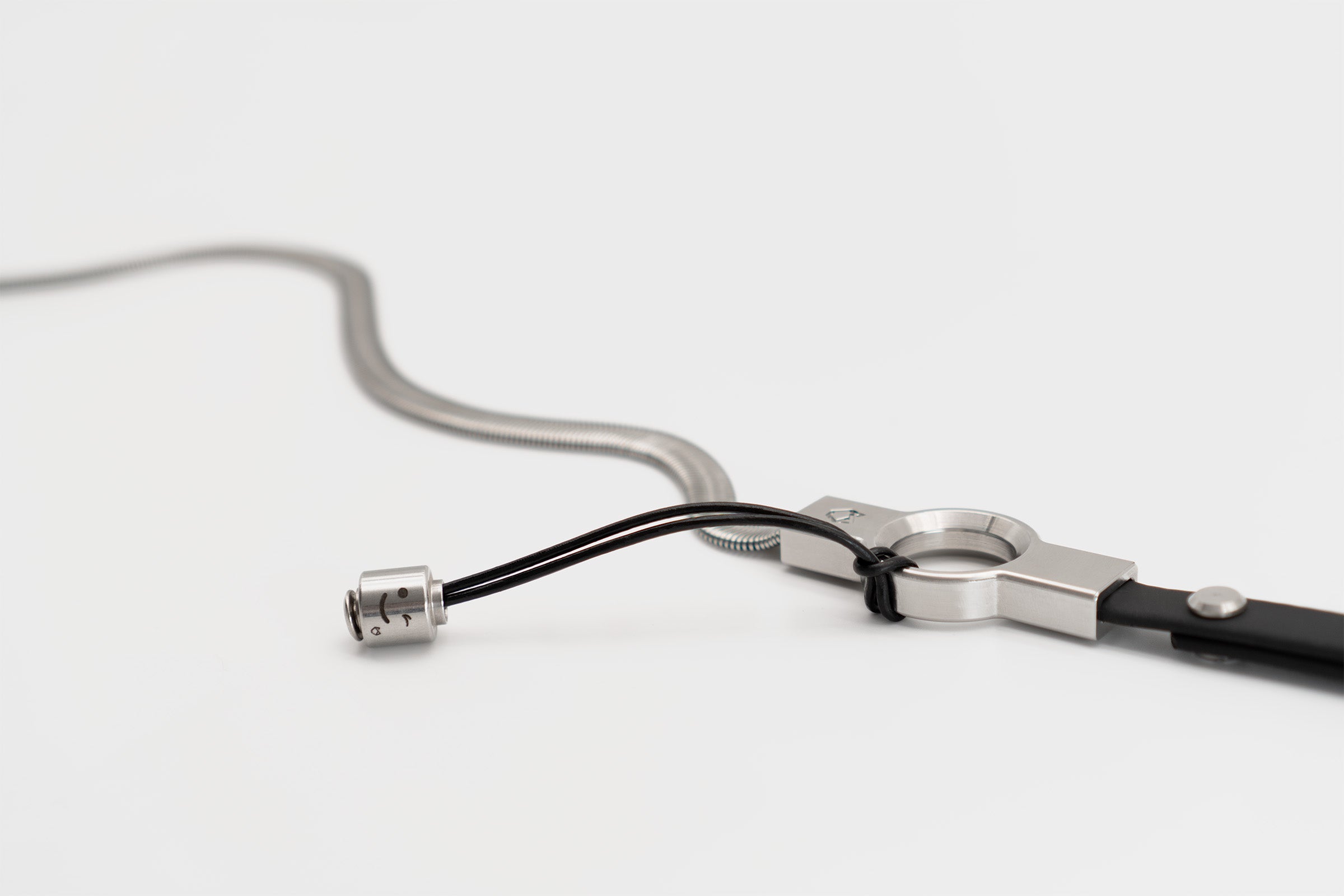 Little Lupo Stainless Steel Pendant with a winking face expression attached to a Little Lupo leash, demonstrating how the pendant adds unique character to the dog leash.