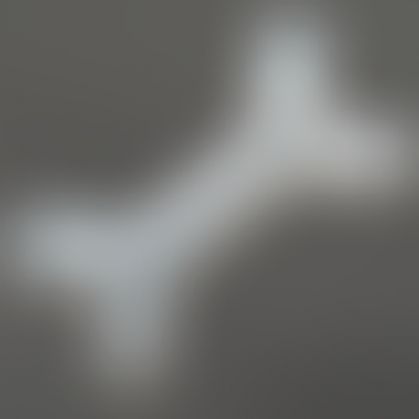 A blurred image of a light grey-colored product on a smooth dark grey background.