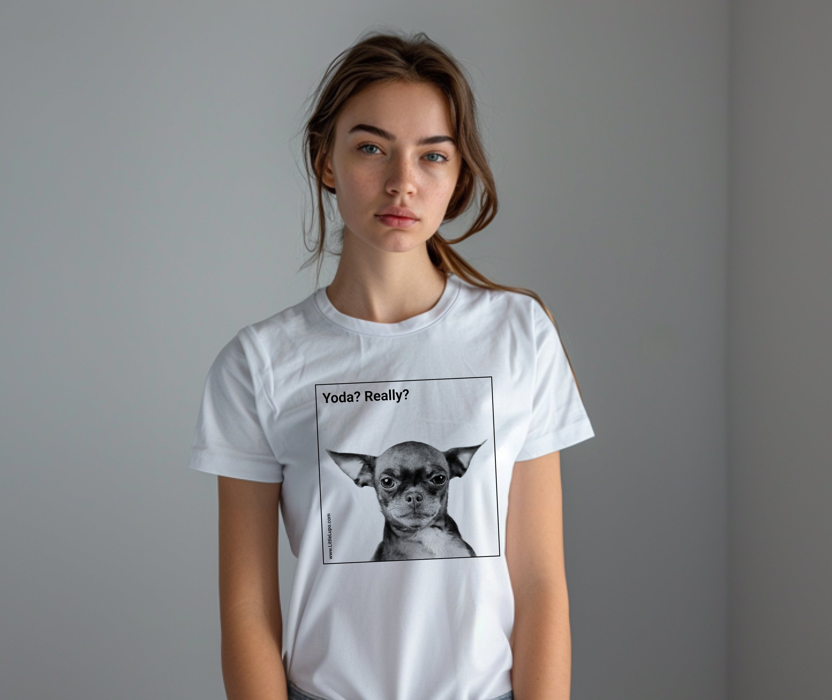 A woman wearing a white Little Lupo t-shirt with a printed black and white image of a dog resembling Yoda from Star Wars, with the text 'Yoda? Really?'.