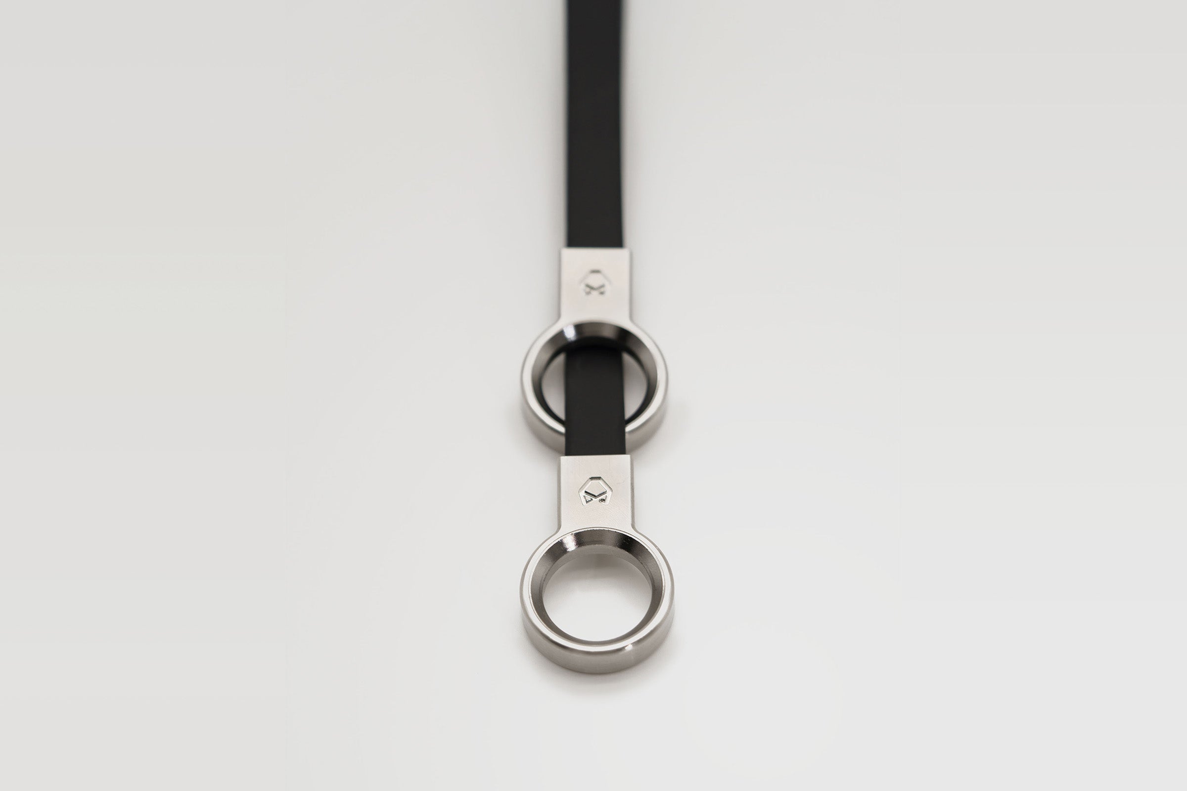 Overhead shot of the Little Lupo Collar C3's CNC machined stainless steel rings and black coated nylon webbing, emphasizing the minimalist and robust design.