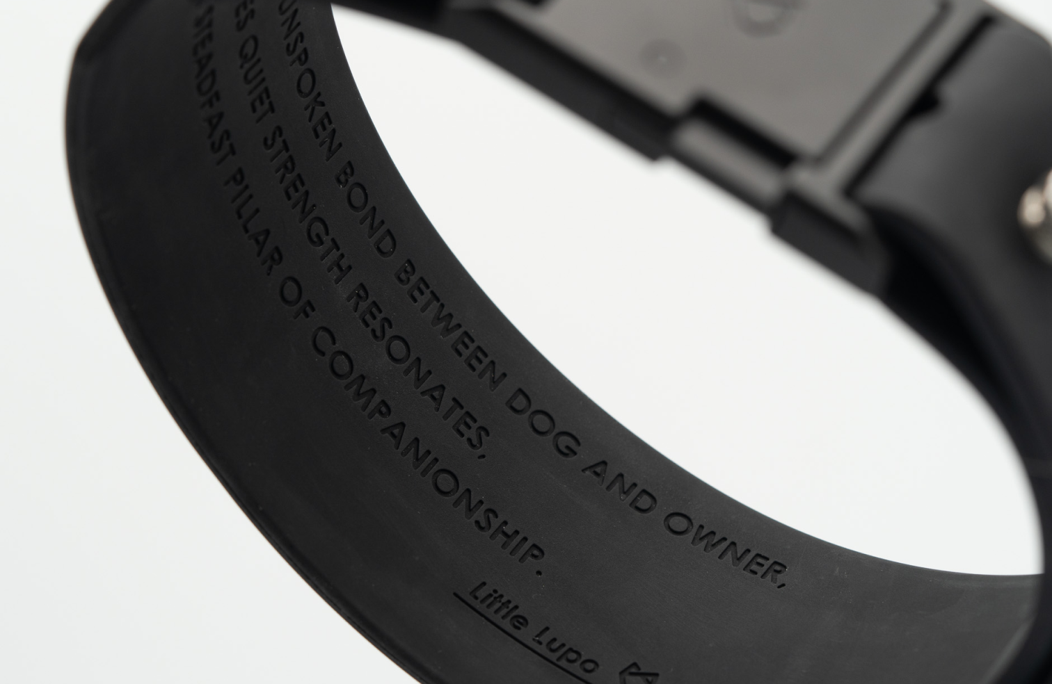 Interior view of Little Lupo Collar C1 showing debossed text "IN THE UNSPOKEN BOND BETWEEN DOG AND OWNER, LOVE'S QUIET STRENGTH RESONATES, A STEADFAST PILLAR OF COMPANIONSHIP. Little Lupo" highlighting brand values on the waterproof LFGB silicone.