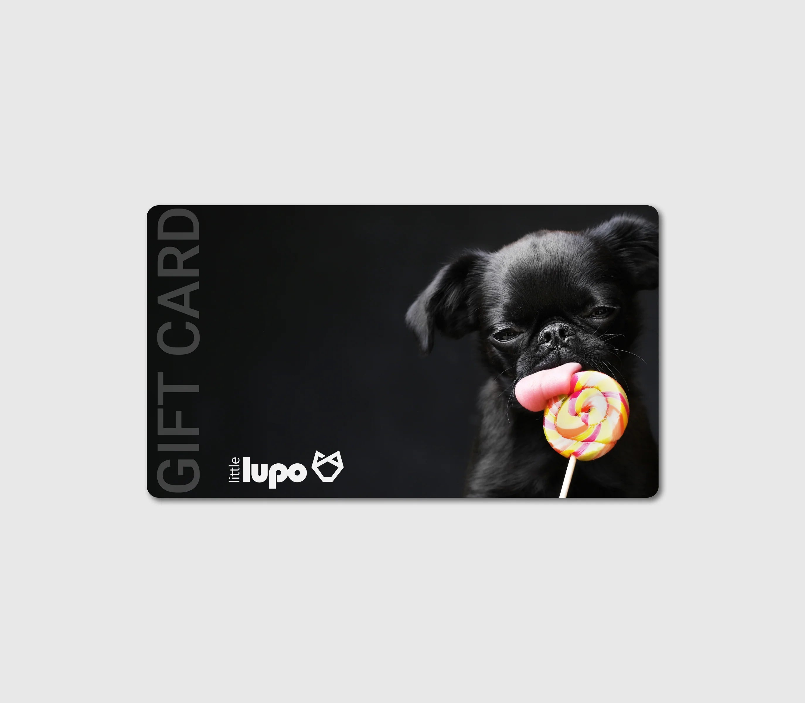Top view of the Little Lupo e-gift card illustration: a small black dog on the right, playfully licking a colorful lollipop. The background is dark grey, with the white Little Lupo logo and "Gift Card" text positioned on the left.
