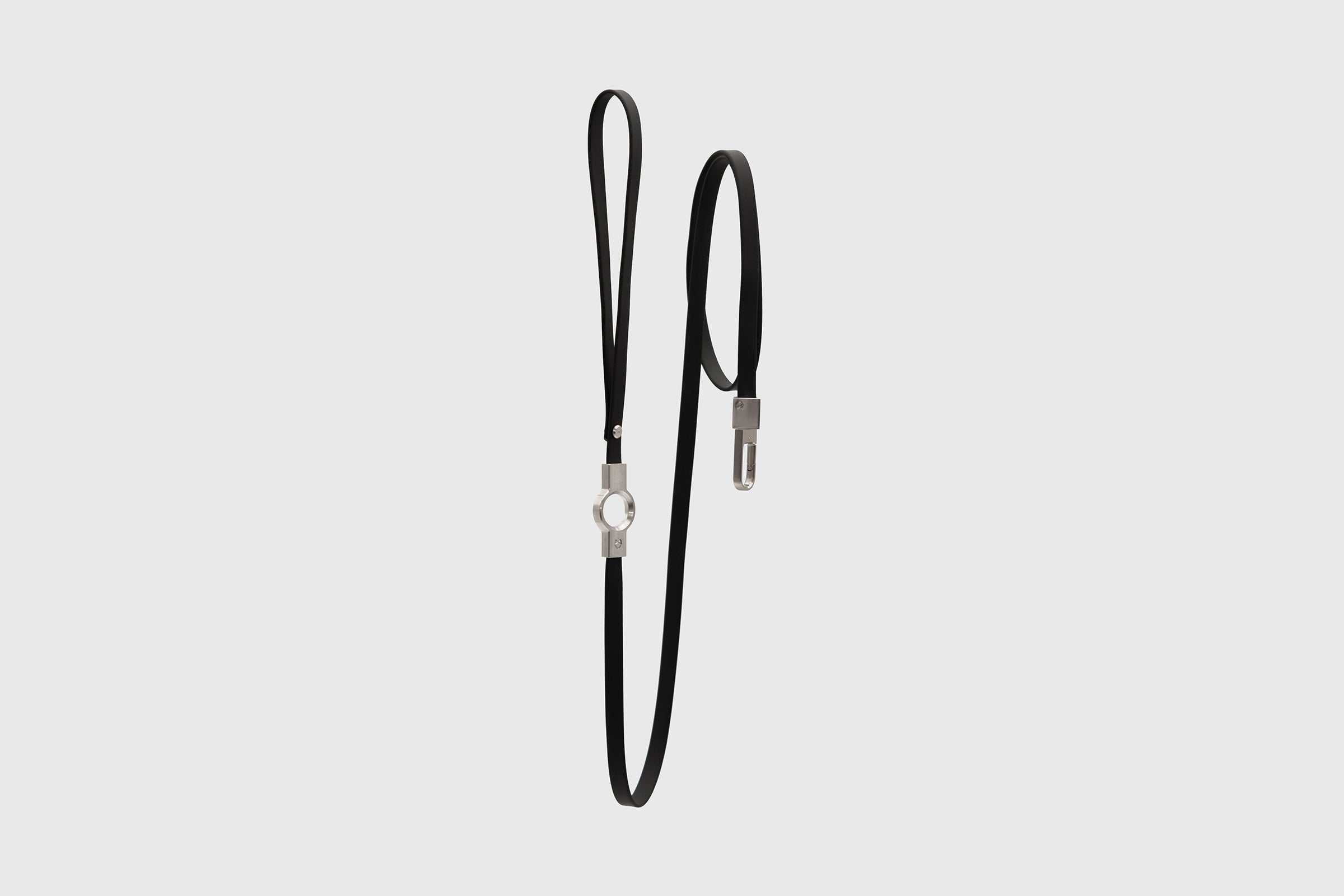 Full vertical view of the Little Lupo Leash L1, a sleek 54-inch black leash made from silicone-coated tactical nylon webbing with stainless steel fittings, on a light background.